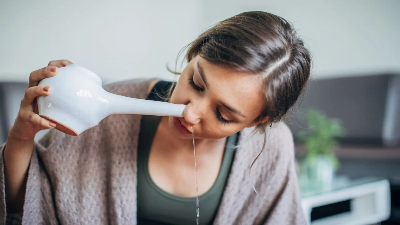 An illustration of the Neti Kriya practice, depicting an individual using a Neti pot to clear the nasal passages, which is a traditional yogic purification method.
