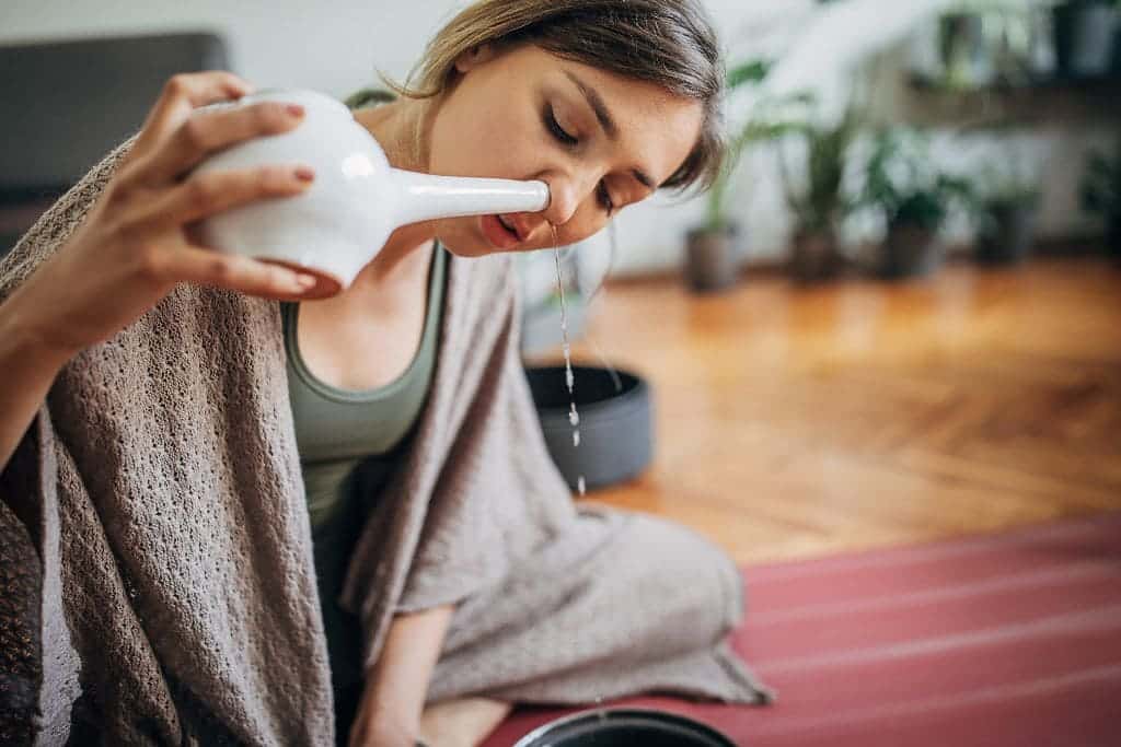 Person practicing Jala Neti using a Neti pot for nasal cleansing as part of the Neti Kriya technique.