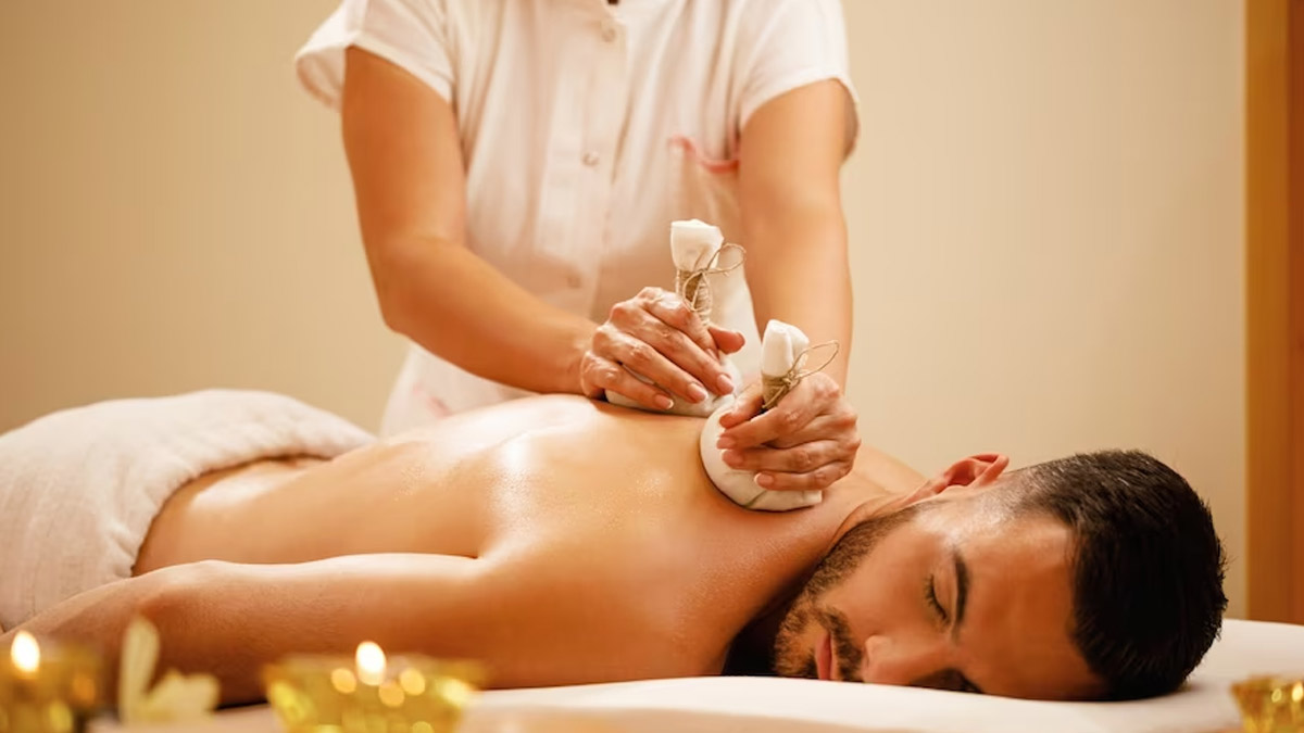 An Ayurvedic therapist applying a heated herbal potli to a patient's back, providing relief through Potli Massage therapy. The treatment area is serene and calming, enhancing the holistic healing experience.